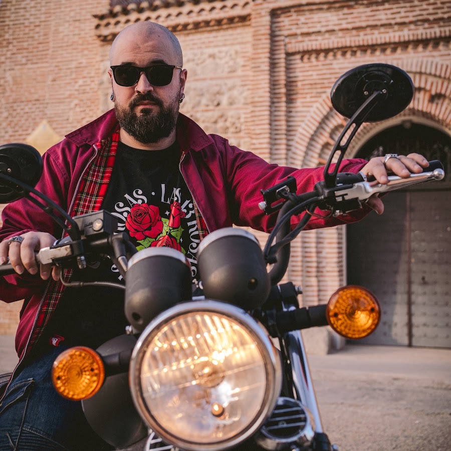 Fita en moto, con gafas de sol y chaqueta granate